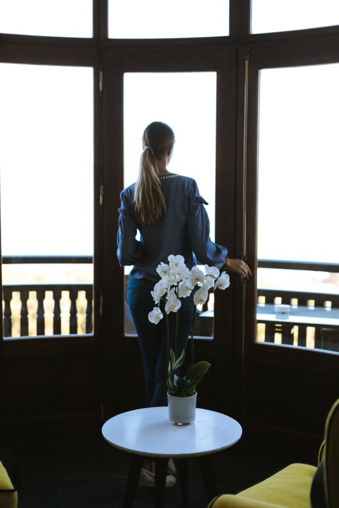 lonely philophobe woman in front of a window