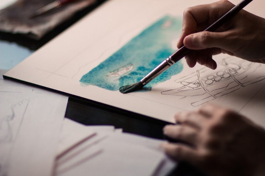 person painting while watching e-learning class