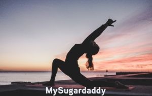 girl practicing yoga near beach