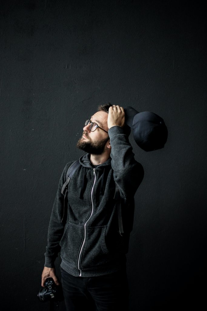 man scratching his head while thinking about his new year's resolutions
