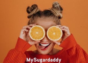 girl holding vitamin rich fruits to her eyes