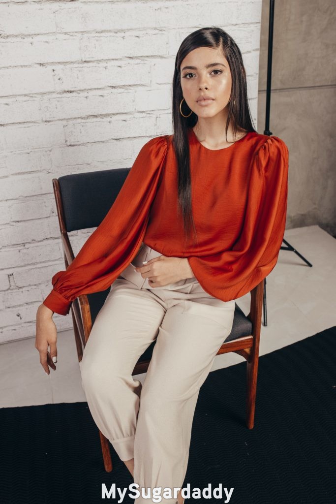 woman in pleated trousers and red blouse