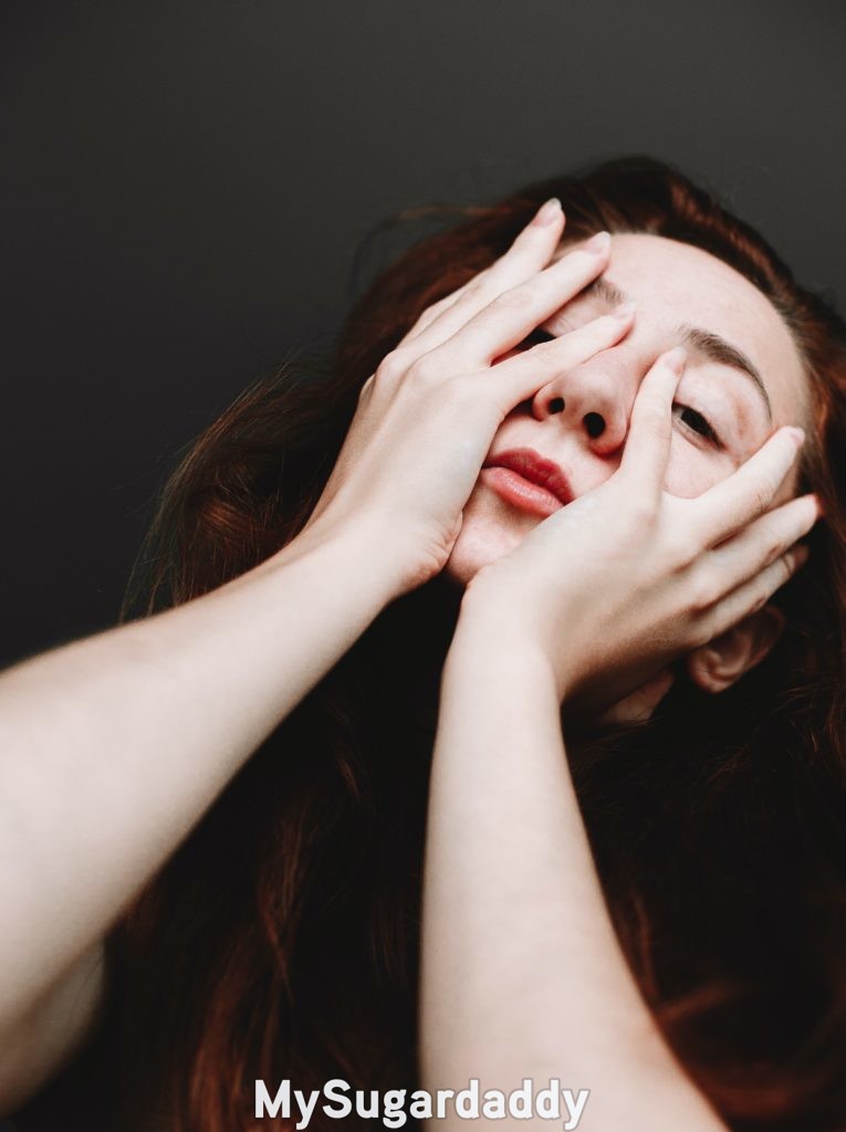 woman covering her face with her hands as reaction to a faux pas